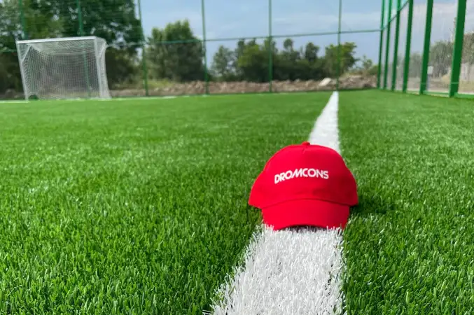 Teren de sport cu gazon artificial și șapcă Dromcons pe linia de marcaj
