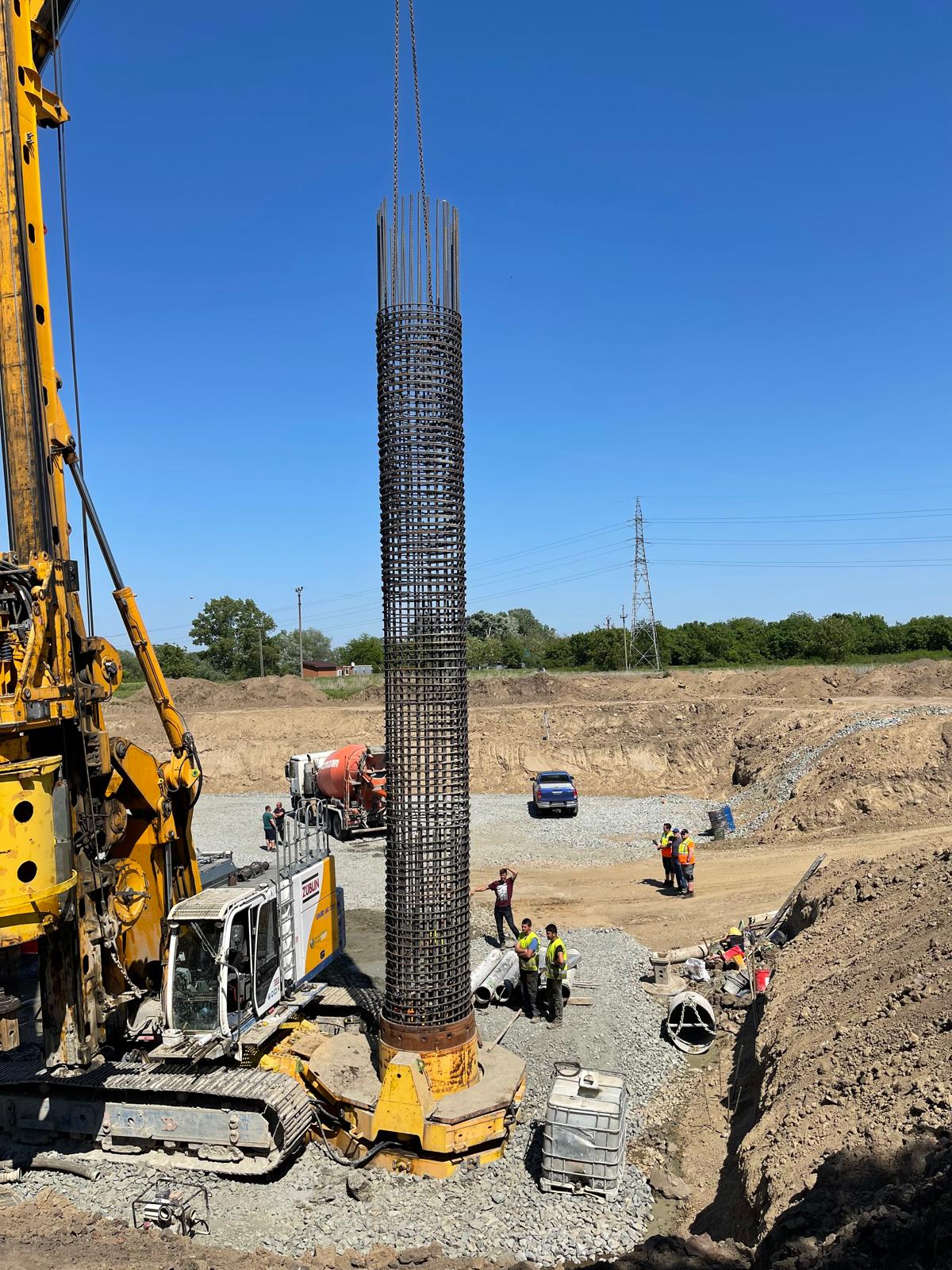 Șantier de autostradă cu utilaj de foraj și cușcă de armătură pentru micropilot