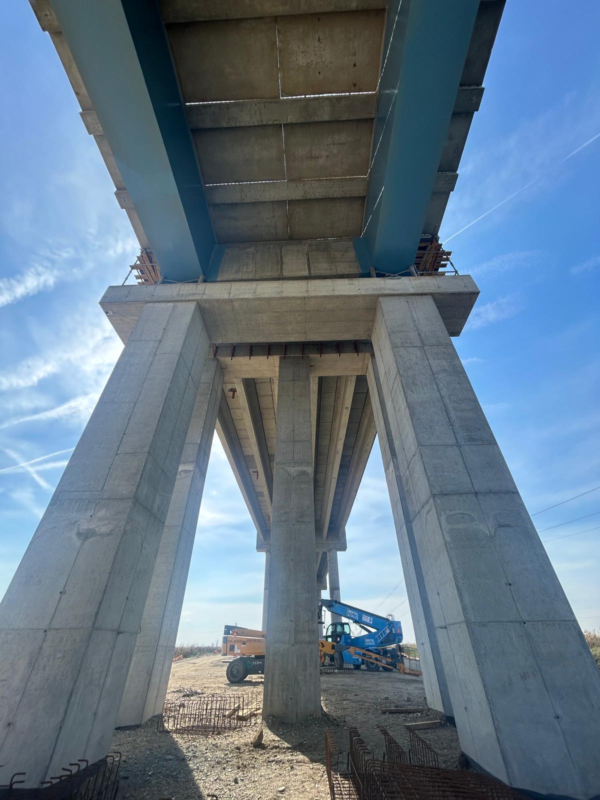 Structură de pod din beton și oțel văzută de dedesubt, în fază avansată de execuție