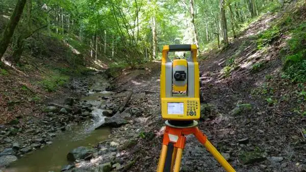 Topograf Dromcons realizând măsurători cadastrale în teren