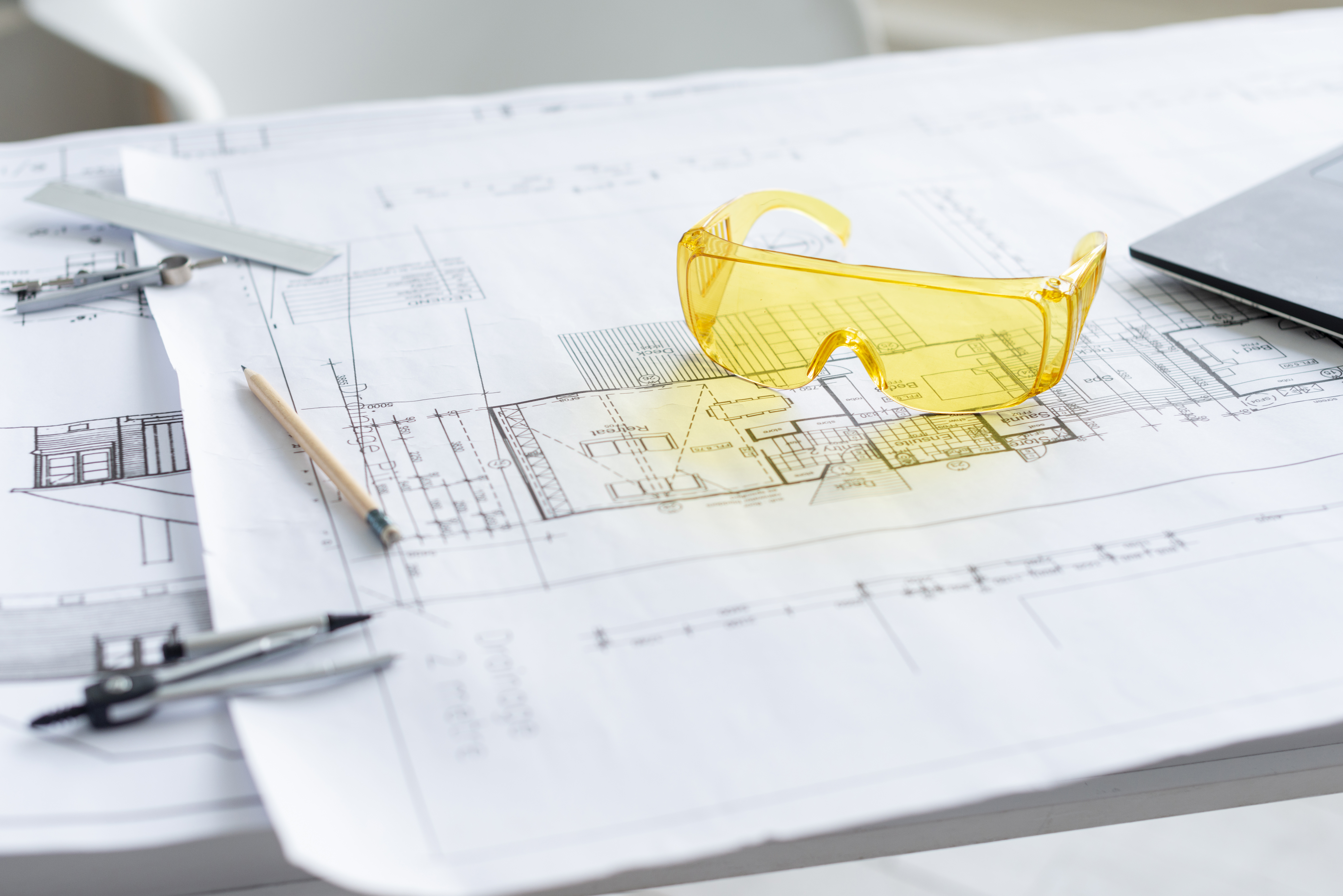 Technical drawings and safety glasses used in civil construction design