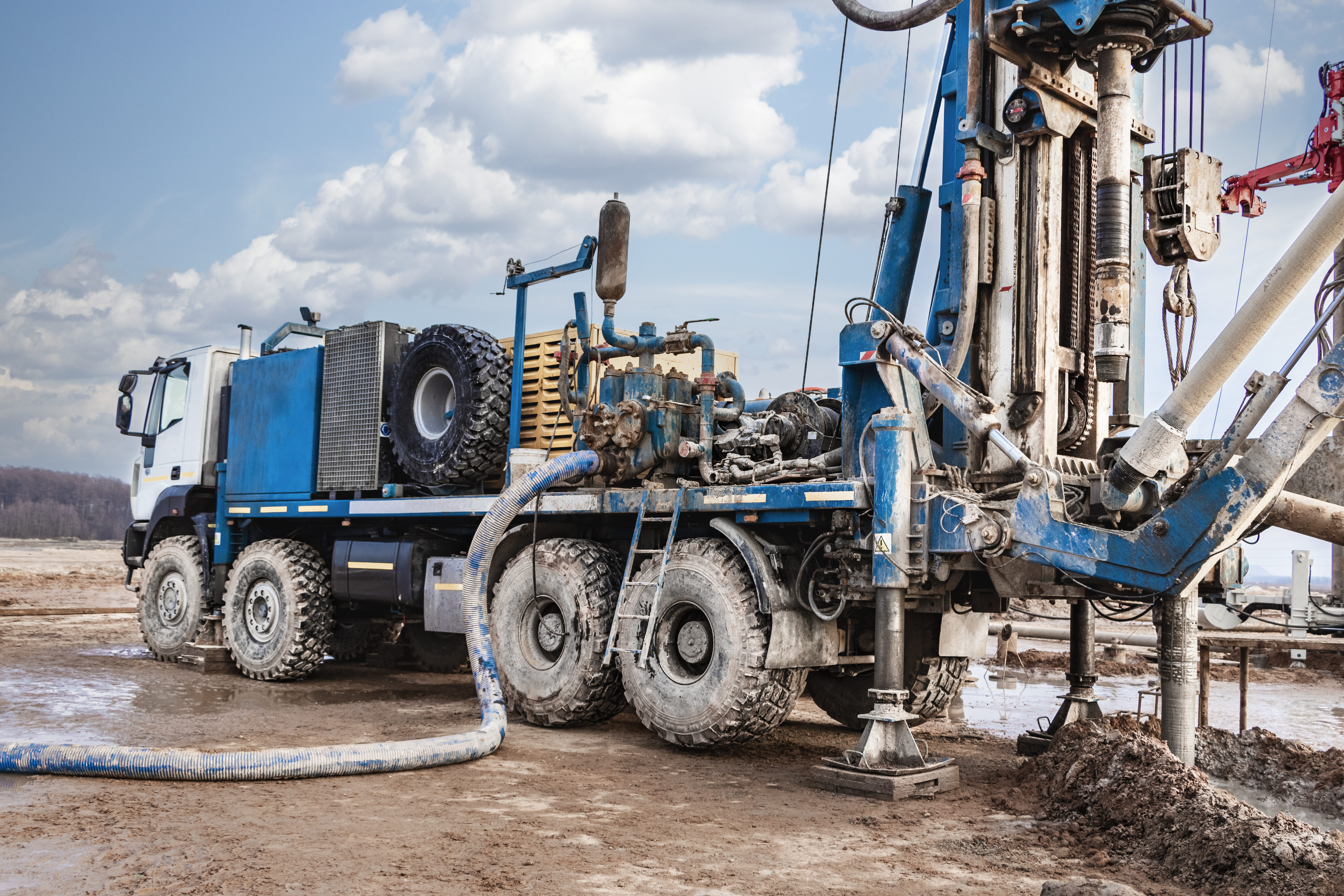 Geotechnical drilling rig on site with a blue Dromcons truck